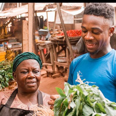 African market seller with a client at a local market stall